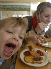 Chowing down on a hamburger and potatoes, Levi Booth, 2, makes a face at Local Burger, 714 Vt. The restaurant, which sells locally grown organic food, will be the focus of a new TV program series debuting on the Sundance Channel featuring earth-conscious programming.