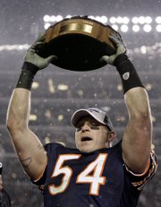 Chicago's brian urlacher hoists the conference championship trophy after the Colts and Bears earned trips to the Super Bowl. The Lamar Hunt Trophy was awarded to the Colts on Sunday in Indianapolis, while the Bears won the George Halas trophy Sunday in Chicago.