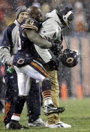 Chicago running back Thomas jones (20) lifts coach Love Smith at the end of the NFC championship game. Smith became the first black head coach to qualify for the Super Bowl and was followed hours later by Indianapolis' Tony Dungy.