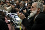 Afghan parliament members pray after the opening speeches of President Hamid Karzai on Sunday in parliament in Kabul, Afghanistan. The Taliban will open schools in areas under their control in Afghanistan, the group's purported chief spokesman said, in an attempt to undermine Karzai's authority.