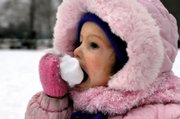After crying during a sled ride earlier, Naomi Symmonds feasts on some snow Sunday at Detweiller Park near Peoria, Ill.