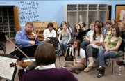 Members of the Cypress String Quartet at left, Ethan Filner, viola, top, and Cecily Ward, back to camera, perform a piece by composer Charles Ives for members of the Lawrence High School orchestra during a workshop. LHS students were "commissioned" by the Cypress String Quartet to help complete a short film, inspired by the music of the quartet, that will play in the lobby of the Lied Center before the quartet&squot;s performance Friday night. The musicians visited several Lawrence schools Wednesday.