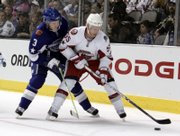 Calgary's Dion Phaneuf, left, challenges the New York Islanders' Jason Blake. The West won the NHL All-Star game, 12-9, on Wednesday night in Dallas.
