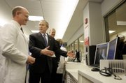 President Bush tours the emergency room Thursday at St. Luke's East Hospital in Lee's Summit, Mo. At left is Jim Hart, of St. Luke's Health System.