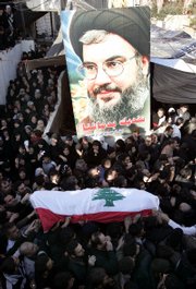 Relatives of Adnan Shams, 25, who was killed during Thursday's confrontations that erupted between government and opposition supporters, carry his coffin next to a poster of Hezbollah leader Sheik Hassan Nasrallah during Shams' funeral procession Friday in Beirut, Lebanon.