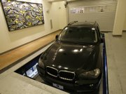 A vehicle is lowered through the floor into an automated parking garage in New York. The parking garage will open in February.