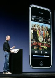Apple CEO Steve Jobs plays a Beatles Song from the "Sgt. Pepper&squot;s" album on iTunes as he introduces the new iPhone at MacWorld in San Francisco in this Jan. 9 file photo. Apple said Monday that it settled long-simmering trademark issues with The Beatles&squot; Apple Corps Ltd. company about the use of the name "Apple" and apple logos.
