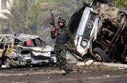 An Iraqi army soldier secures the site of a double car bomb attack in southern Baghdad, Iraq. Even as an Iraqi general took charge of the security operation in the capital and Iraqi police and soldiers manned new roadblocks, violence flared Monday in Baghdad with car bombs and mortar attacks.