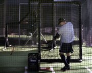 New York Yankees players take swings in the batting cage at the team's spring training complex in Tampa, Fla. Major-league pitchers and catchers report to camps starting Tuesday.