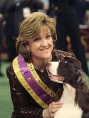 An English springer spaniel named Diamond Jim, also known as James, poses with his handler Kellie Fitzgerald after winning best in show Tuesday at the 131st Westminster Kennel Club dog show in New York City.