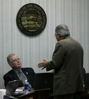 Kansas State Board of Education Chairman Bill Wagnon, left, and board member Kenneth Willard discuss science standards after the board adopted new, evolution-friendly science standards for Kansas public schools in a 6-4 vote. Wagnon voted Tuesday for the standards and Willard voted against them, as the board changed the science standards for the fifth time in eight years.