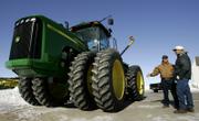 Leoti Greentech salesman Robbie Berning, left, talks to Healy farmer Vance Ehmke about a new tractor. With higher crop prices and a break in drought conditions, many farmers are in the market for new equipment.