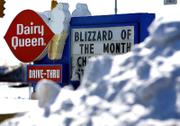 A Dairy Queen sign advertises the "Blizzard of the Month" as piles of snow surround the parking lot in Sidney, Ohio. Much of Ohio was shut down Wednesday when snow and ice closed schools for a second day and many workers heeded warnings to stay off treacherous roads.