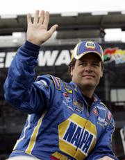 Michael Waltrip waves to fans as drivers are introduced before the first of two Gatorade Duel qualifying races. Waltrip placed eighth in his race Thursday in Daytona Beach, Fla.