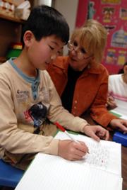 Gyong MIn Moon, 11, gets some special attention from his teacher Karen Ward, an English Language Learner intermediate instructor at Hillcrest School. The English as a Second Language program at Hillcrest has grown from 115 to 285 students in the past six years. Hillcrest serves more than half of the Lawrence school district's ESL students.