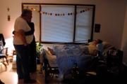 Miles and his daughter Sara hold one another early in the morning watching Kathy sleep after she had been restless and uncomfortable. Miles called a Douglas County Hospice nurse before administering a medication that helped her sleep.