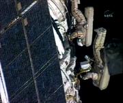 In this image from NASA Television, Commander Michael Lopez-Alegria, left, and Russian flight engineer Mikhail Tyurin work during a spacewalk Thursday on the international space station.