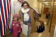 Michelle Eagleman and her daughter, Saya, 7, exit a poll booth at the Lawrence High School Annex. Eagleman cast her vote on Tuesday at the voting station for the 27th precinct.