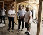 Mississippi Gov. Haley Barbour, left, and President Bush visit a home being rebuilt in Long Beach, Miss., after Hurricane Katrina. The president said he wanted to let people know they have not been forgotten and to show American taxpayers how their money is being used for recovery.