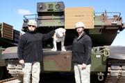 Col. Norb Jocz, left, and Sgt. Maj. James Savitski pose with Chester the bulldog and a new tank Friday at Fort Riley.