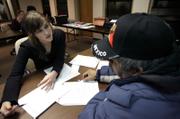 Volunteer Ellen Ritchie, left, helps a Hispanic worker fill out paperwork in an effort to collect unpaid wages from an employer in Kansas City, Kan. The Kansas City Worker Justice Project helps workers collect wages, and, if that fails, helps workers write complaint letters to the U.S. Department of Labor.