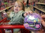 Charlotte LeBaron, 2, reaches for a Polly Wheel at a Target store. Mattel is combining dolls and cars in the first line of miniature die-cast racers just for girls. The cars are paired with the company's Polly Pocket dolls.