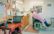 Olin Dalaba, 72, who has been a barber in McLouth for almost half a century, chats recently with customer Melvin Bundy, of rural Tonganoxie. The barbershop has long been a venue in the community where people get together and pass the time. Increasing use of the Internet, cell phones and other technology has raised fears that people are engaging in less face-to-face interaction with other people.