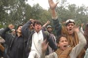 Afghan men shout anti-American slogans after a car bomber attacked an American convoy in eastern Afghanistan on Sunday. Following the bombing, witnesses said, U.S. troops opened fire on civilians, killing at least eight. Hundreds of Afghans gathered to protest the violence, blocking the road and throwing rocks at police.