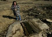 Robin Bailey stands by a dried-up, abandoned well on her farm near Stockton last month. Bailey blames nearby irrigation wells for drying up bodies of water on her farm.