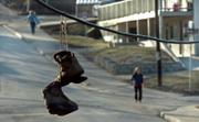 An old pair of boots dangle from a power line as pedestrians make their way down 14th Street near Tennessee late Wednesday afternoon.