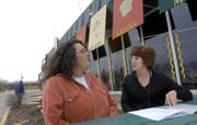 Mercedes Taylor-Puckett, left, downtown Lawrence Farmers Market coordinator, and Jeanie Wells, Community Mercantile general manager ,discuss their efforts to open a new Farmers Market on Wednesdays in the Community Mercantile parking lot at 901 Iowa. The two were outside the Community Mercantile on Thursday.