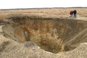 Mickey Center, left, and Murray Balk peer into a ground cave collapse caused by undermining in Galena, Ks., measuring 90-100 feet deep. The Kansas Department of Health and Environment's Surface Mining Section has filled more than 700 coal mine collapse since 1996. 'We get calls every day," Balk said. "Especially when it rains because more of them open up."