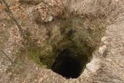 An eight-feet wide air vent dropping hundreds of feet below to a lead and zinc mine appears suddenly, without warning, in a wooded area south of Galena, Ks. Law enforcement have searched some of these shafts for missing people and have recovered murder victims dumped into the shafts.