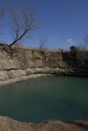 During the summer months, kids flock to this sinkhole filled with water north of Treece, Kan., and rope swing off the tree at upper left. Health officials worry about the long-term effects of exposure to the water filling these abandoned mines.
