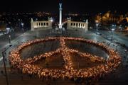 Thousands of demonstrators holding lit torches as they form a giant Peace sign on the city's Heroes' Square in Budapest, Hungary, Saturday evening. The protesters were calling for foreign troops to be withdrawn from Iraq. Protests have been taking place across the world to mark the fourth anniversary of the start of the Iraq war.