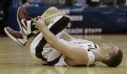 SOUTHERN ILLINOIS FORWARD MATT SHAW grabs his ankle late in the first half of the Salukis' 61-51 victory against Holy Cross in the opening round of this year's NCAA Tournament. Shaw didn't return to Friday's game, missed Sunday's win against Virginia Tech and is questionable for Thursday's Sweet 16 matchup with Kansas University.