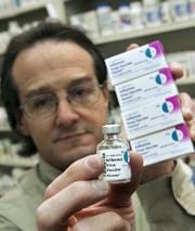 Ira Katz, a pharmacist certified to administer the flu vaccine, holds up his pharmacy's leftover supply of the vaccine at Little Five Points Pharmacy in Atlanta. Millions of doses of flu vaccine will expire at midnight June 30, unsold during this year's mild flu season and written off as trash.