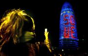 A woman takes a photo with her mobile phone of the lights on the Agbar Tower Friday in Barcelona, Spain. The tower&squot;s lights say "50 UE" in celebration of the European Union&squot;s anniversary. Sunday marks the 50th anniversary of the signing of the Treaty of Rome that created what was then called the European Economic Community. The Rome treaty laid the basic foundations, much expanded by later treaties, for a common currency and central bank.