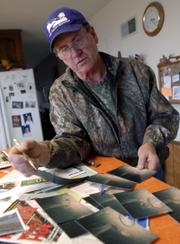 Dan Hanney, 53 N. 1150 Road, has seen plenty of wild hogs around his property west of Clinton Lake and has captured several live in traps and on film using a trail camera with a trip sensor. Hanney looks through some of his photographs of feral hogs on his property. Last week a USDA helicopter and gunman flew over land around Clinton Lake to shoot some of the feral hogs. The wild hogs cause problems for landowners because they carry disease that can spread to other animals and cause damage to land and crops.