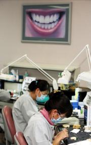 Employees of Ottawa Dental Laboratory in Ottawa, Ill., can earn health "bucks" that can be redeemed for merchandise. So Youn Zepeda, foreground, and her husband received a 42-inch flat-screen television for their living room.