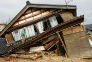 A man goes up a collapsed house to check its damage following Sunday's earthquake in Wajima, Ishikawa prefecture (state), northern Japan today. A powerful quake tore into a rural area of coastal central Japan on Sunday, killing at least one person as it toppled aging farmhouses and temples, set off landslides and caused a small tsunami. Some 170 people were injured.