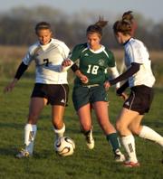Lawrence High's Kaela Severa (7) and Olivia Dykes, right, double-up on Free State's Grace Lang (18). The teams played to a 1-all, double-overtime tie Tuesday at the Youth Sports Inc. fields.