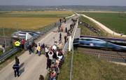A high-speed French train speeds under a bridge filled with reporters and onlookers, breaking the world rail speed record near Grigny, eastern France. The train hit 357.2 mph on Tuesday. However, it fell short of the ultimate record set by Japan's nonconventional magnetically levitated train, which sped to 361 mph in 2003.
