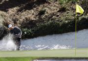 Tiger Woods hits from a bunker on the 12th hole. Woods shot a third-round 72 at the Masters on Saturday in Augusta, Ga.