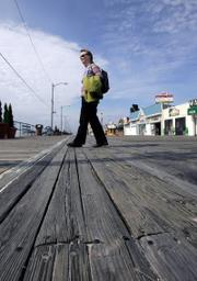 Georgina Shanley, an environmentalist, walks across the worn planks of the boardwalk in Ocean City, N.J. The town sought $1.2 million worth of Brazilian wood certified as having been harvested responsibly, to repair the boardwalk. "Every second, 1.5 acres of rain forest is lost, and with it, thousands of plants and animals and habitat for the humans living there," Shanley said.