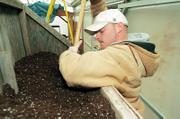 Josh Erhart, Lawrence, mashes potting soil into a chute early this spring so his co-workers at Clinton Parkway Nursery, 4900 Clinton Parkway, could collect it for freshly potted seedlings. The early start of daylight saving time this year made consumers start thinking spring early - and nurseries were among businesses who tried to cater to the March madness.