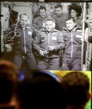 People watch A TV screen at Mission Control in Korolyov, Russia, showing the crew aboard the international space station. In back row, from left, are Miguel Lopez-Alegria, Mikhail Tyurin and Sunita Williams, and in front row, from left, are Fyodor Yurchikhin and Oleg Kotov of Russia and American software billionaire Charles Simonyi.