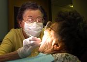 Dental hygienist Geneva Will works on patient Darlene Gutsch in Dr. Richard Mosier's office in Herington. Will, 76, has been a hygienist longer than anyone else in the state.