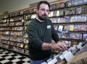 Clark Morton, of Lawrence, flips through his inventory of newly arrived music at the CD Tradepost, 4000 W. Sixth St., one of the Morton family businesses. Clark's father, Jerry, said that because they sell a lot of used CDs, the digital download trend doesn't hurt their bottom line as it might for retailers who sell new music.