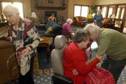 As Mae Bugert leaves the room, Beverly Edwards and Marion Howie greet each other with a hug in the activities room at Pioneer Ridge Retirement Community, 4851 Harvard Road. Remaining active throughout life is one way seniors can ward off depression.